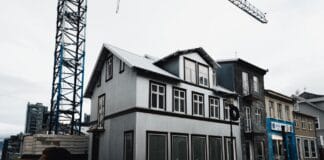 Nowoczesny szeregowiec z metalową elewacją i dźwigiem na spokojnej ulicy