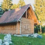 Drewniana chatka z bali wśród spokojnego leśnego krajobrazu