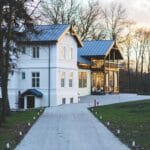 Drewniany dom z oświetlonym podjazdem i ogrodem o zachodzie słońca