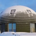 Kopułowy dom na śniegu pod zimowym, błękitnym niebem