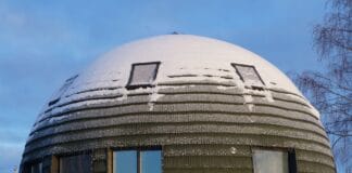 Kopułowy dom na śniegu pod zimowym, błękitnym niebem